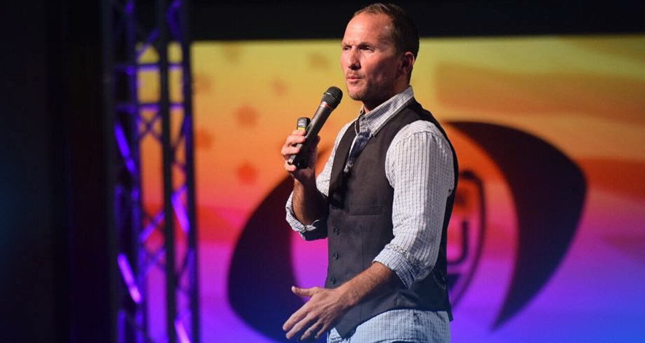 Dr. Kevin C. Snyder delivering a keynote on stage with microphone