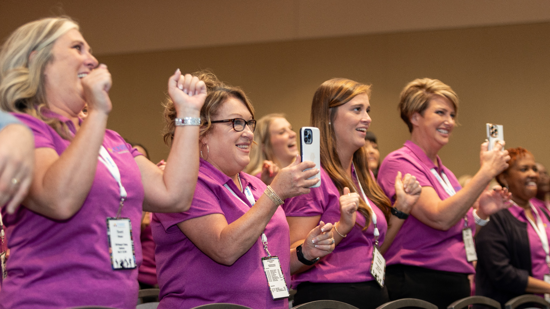 Audience members on their feet cheering at a manager conference